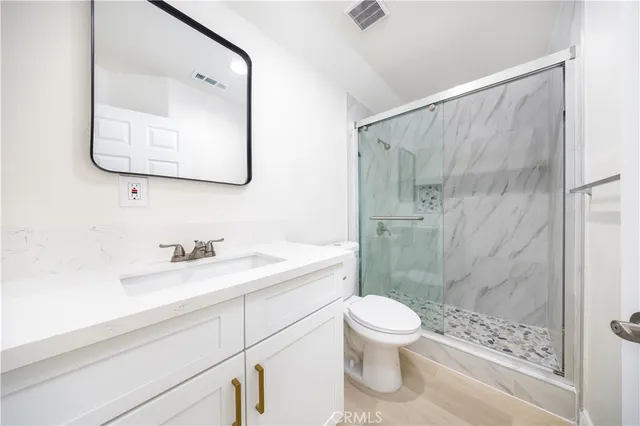 a bathroom with a sink a toilet and shower