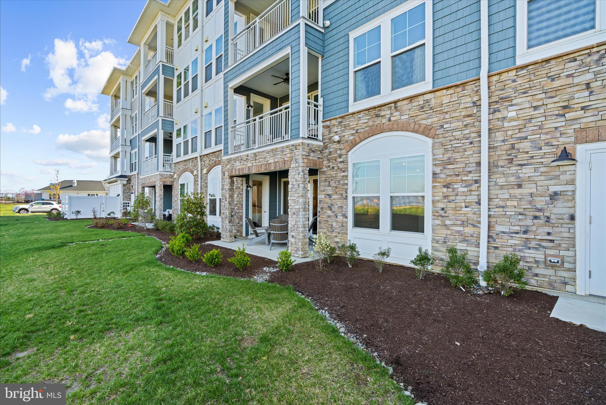 132 Wheelhouse Way, Unit 11 Chester, MD 21619 - Photo 31 of 77 a view of a brick building next to a yard