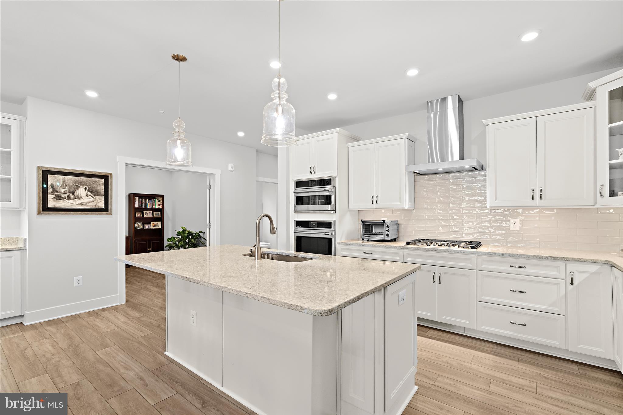 132 Wheelhouse Way, Unit 11 Chester, MD 21619 - Photo 4 of 77 a kitchen with stainless steel appliances kitchen island granite countertop a stove a sink a refrigerator and white cabinets with wooden floor