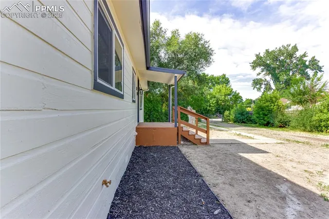 a view of a patio with a table and chairs next to a yard