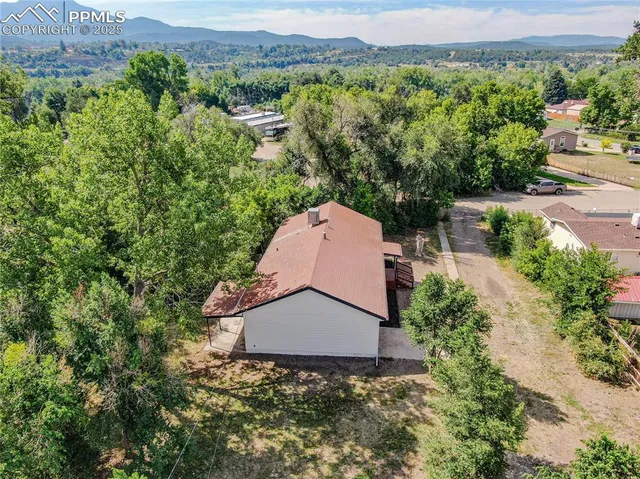 an aerial view of a house with a garden and a yard