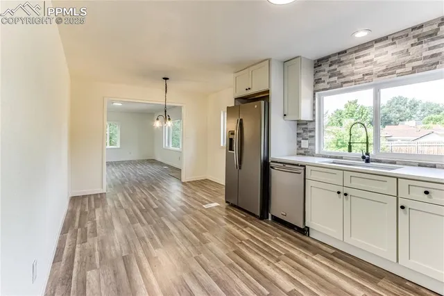 a view of a kitchen with wooden floor and a window