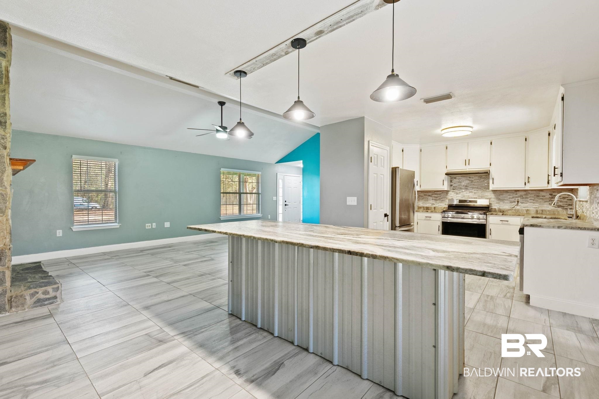 17366 Old Brady Road Bay Minette, AL 36507 - Photo 11 of 43 Kitchen with stainless steel appliances, light stone counters, hanging light fixtures, vaulted ceiling, and ceiling fan