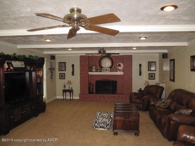 6306 Jameson Road Amarillo, TX 79106 - Photo 12 of 32 a living room with furniture a flat screen tv and a fireplace