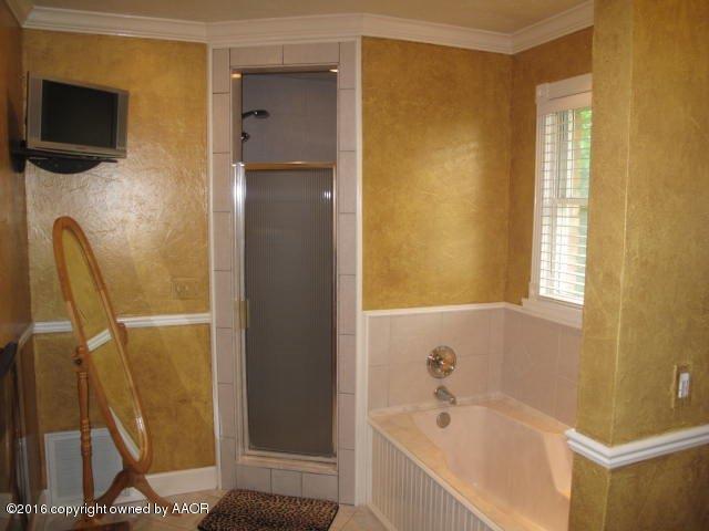 6306 Jameson Road Amarillo, TX 79106 - Photo 19 of 32 a bathroom with a bathtub and a shower
