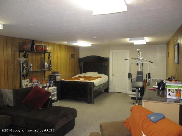 6306 Jameson Road Amarillo, TX 79106 - Photo 22 of 32 a living room with furniture a mirror and gym equipment