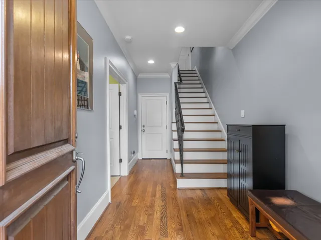a view of hallway with stairs and wooden floor