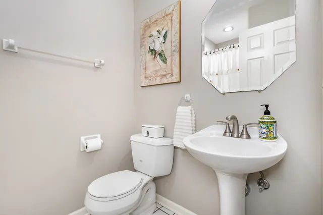 a bathroom with a toilet sink and mirror