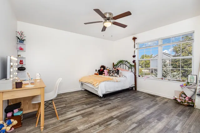 a white bed sitting in a bedroom next to a window