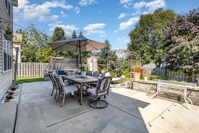 a view of a patio with a table and chairs under an umbrella