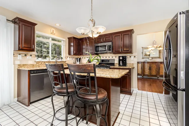 a kitchen with a dining table chairs stainless steel appliances and cabinets