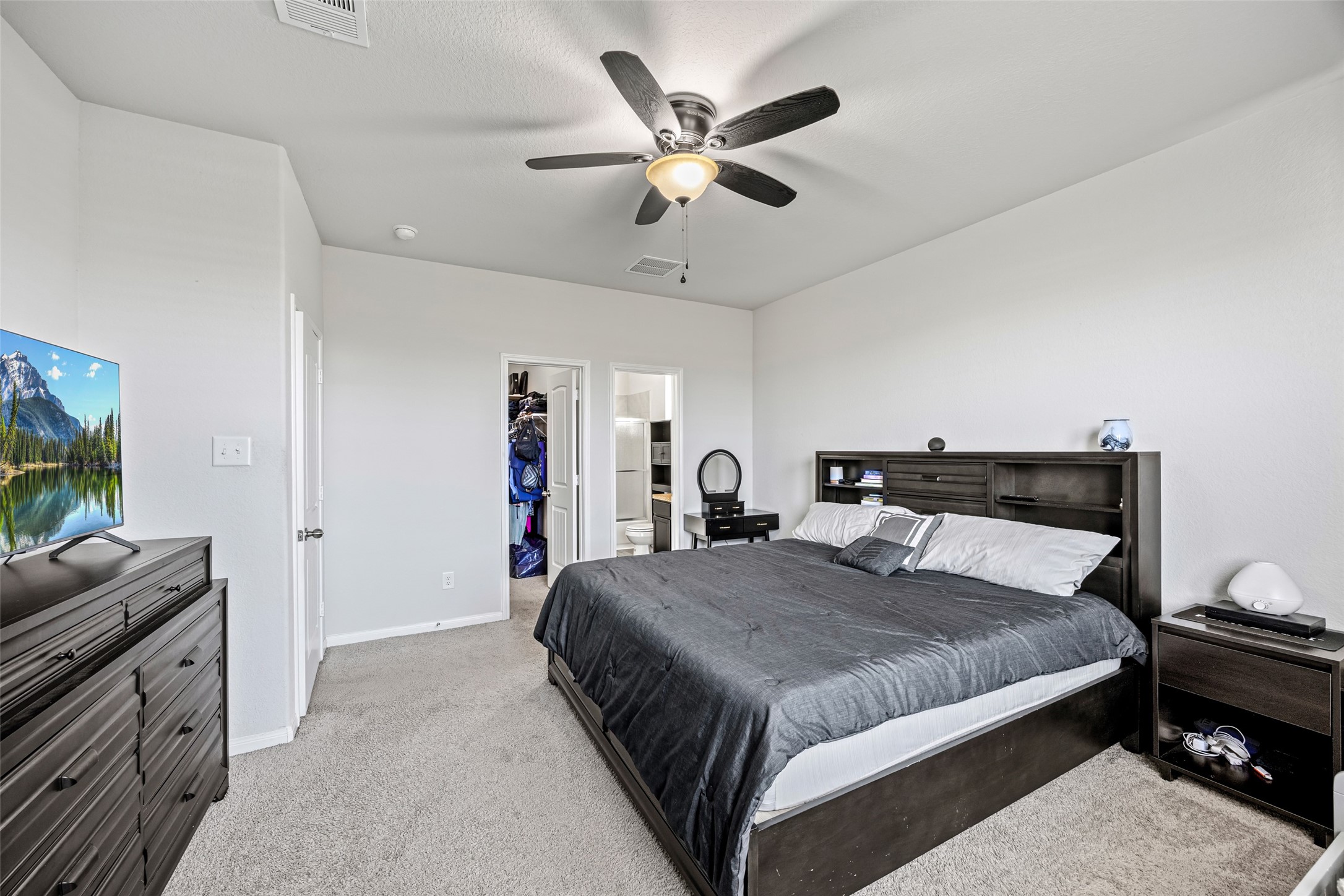 4827 Purple Wisteria Lane Spring, TX 77373 - Photo 17 of 26 a bedroom with a large bed and a flat screen tv