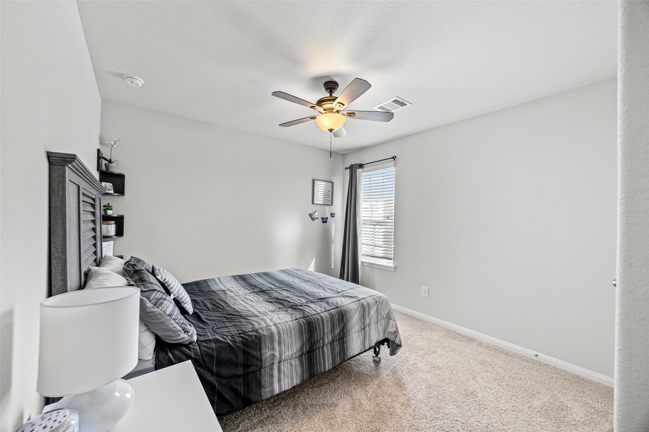 4827 Purple Wisteria Lane Spring, TX 77373 - Photo 24 of 26 a bedroom with a bed and a chandelier