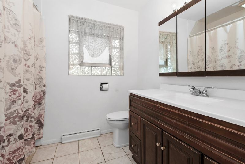 7213 West 109th Street Worth, IL 60482 - Photo 5 of 23 a bathroom with a granite countertop sink a toilet and a mirror