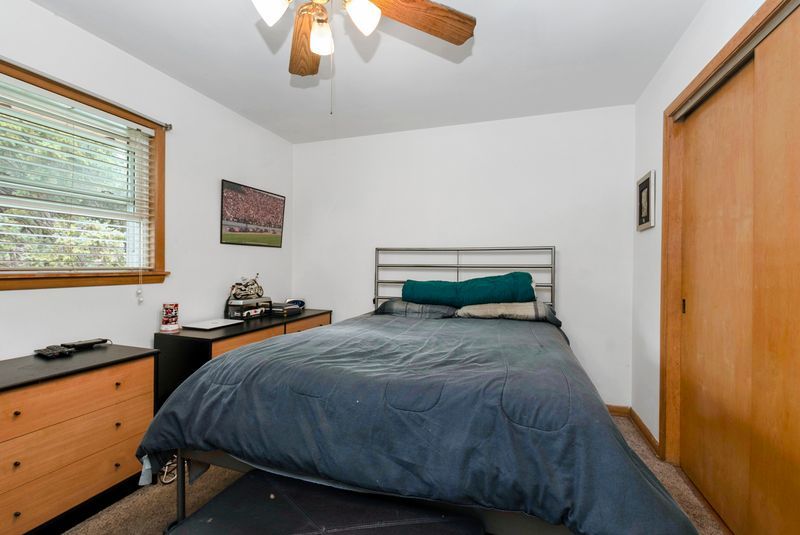 7213 West 109th Street Worth, IL 60482 - Photo 8 of 23 a bedroom with a bed and a chandelier