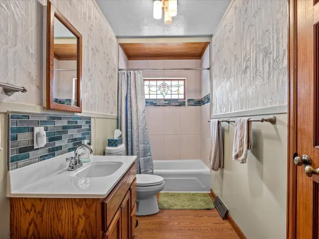 a bathroom with a sink a toilet a mirror and shower