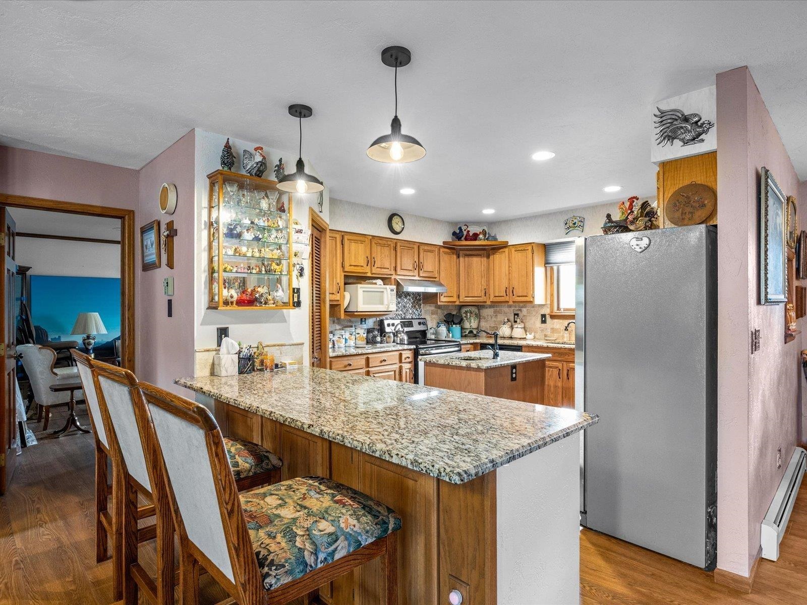 3085 F F 1/2 Road Grand Junction, CO 81504 - Photo 6 of 30 a kitchen with stainless steel appliances granite countertop a refrigerator a sink dishwasher a dining table and chairs with wooden floor