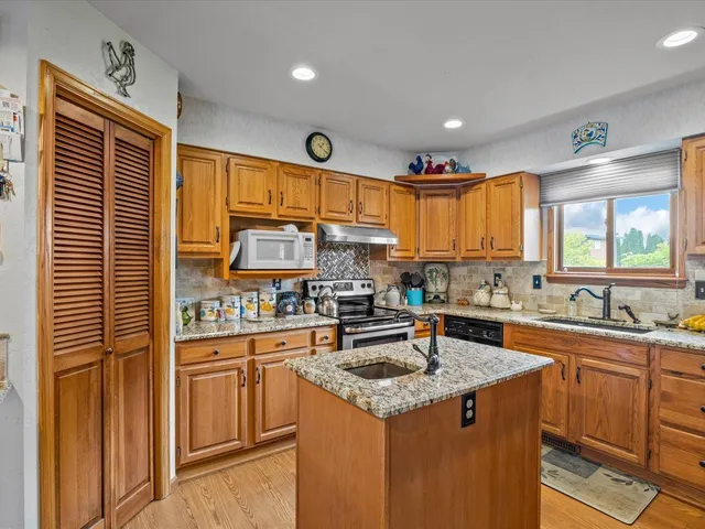 a kitchen with stainless steel appliances granite countertop a sink stove and cabinets
