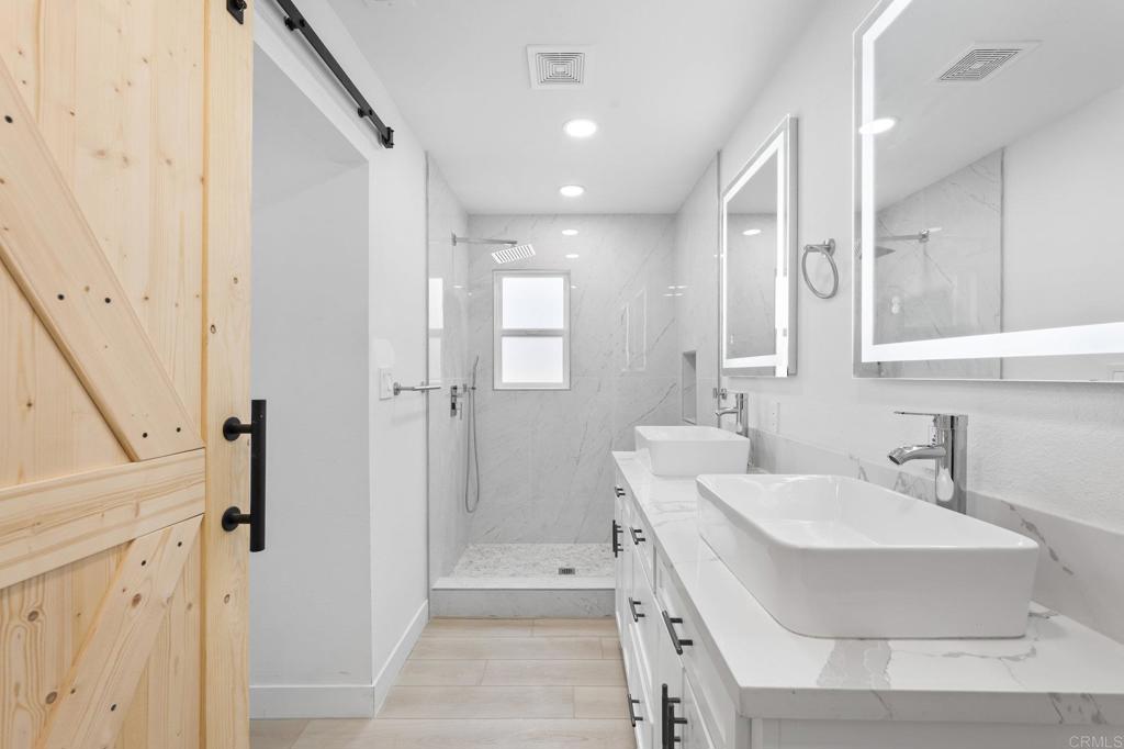 1326 Crestridge Drive Oceanside, CA 92054 - Photo 28 of 29 a spacious bathroom with a bathtub shower sink and mirror