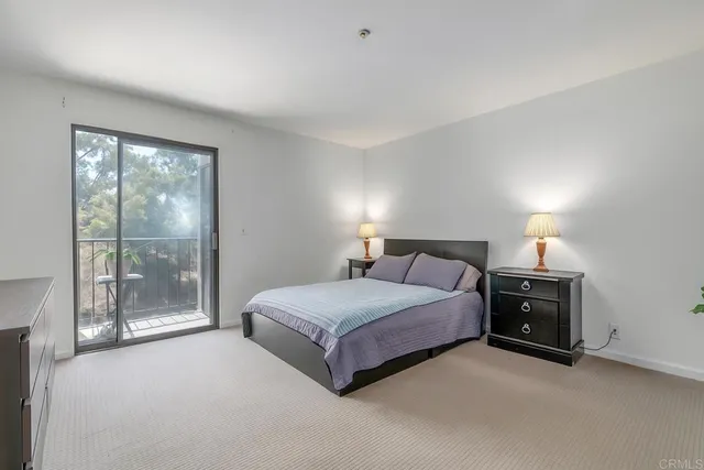 a spacious bedroom with a bed and a lamp