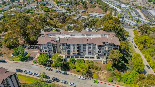an aerial view of a house with swimming pool and large trees