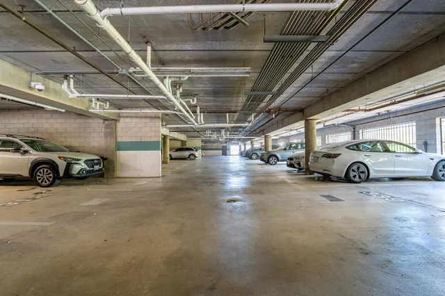 a view of parking garage with cars parked