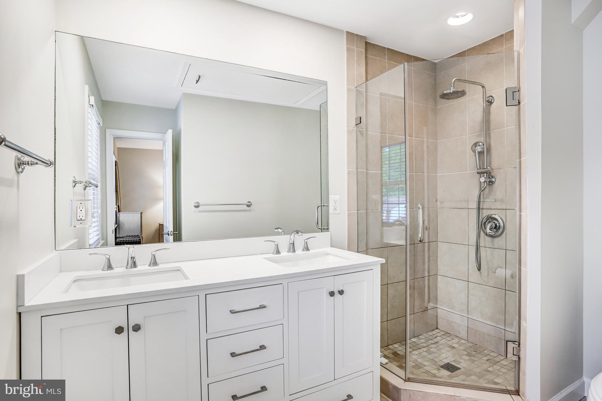 6737 Baron Road McLean, VA 22101 - Photo 17 of 36 a bathroom with a shower sink vanity and mirror