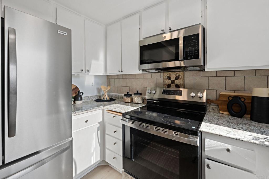 3408 Del Este Way Oceanside, CA 92056 - Photo 10 of 25 a kitchen with stainless steel appliances granite countertop a stove and a microwave