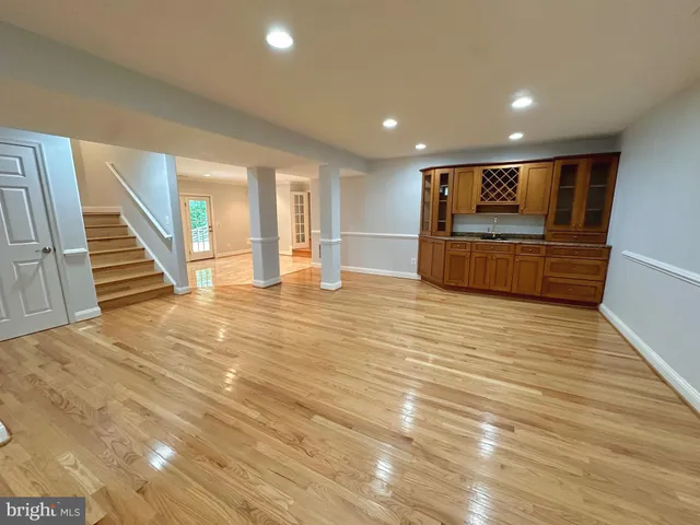 a view of an empty room with stairs and a window