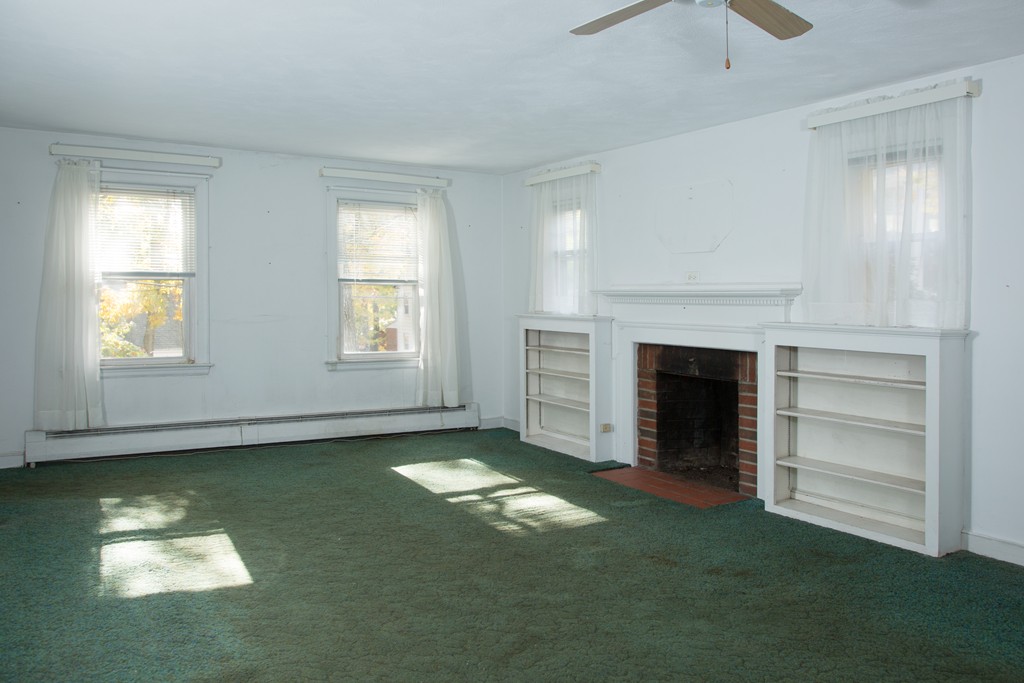 379 Marrett Road Lexington, MA 02421 - Photo 3 of 6 a view of an empty room with fire place and a window