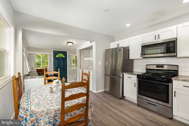 a kitchen with stainless steel appliances a stove a refrigerator and a microwave