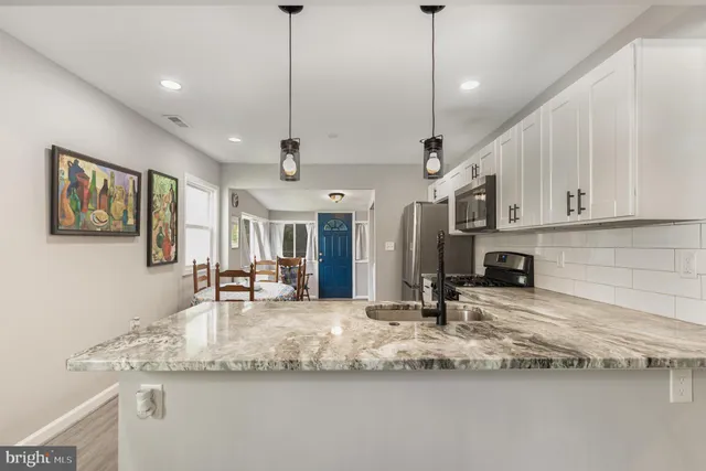 a view of a kitchen with granite countertop a sink a counter top space and cabinets