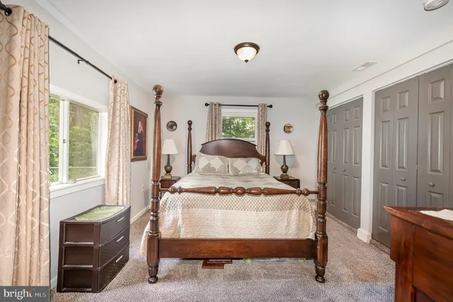 a bedroom with a bed and large windows