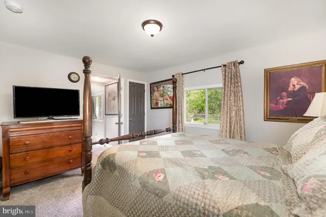 a bedroom with a large bed and flat tv screen on dresser
