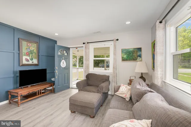 a living room with furniture a flat screen tv and a window