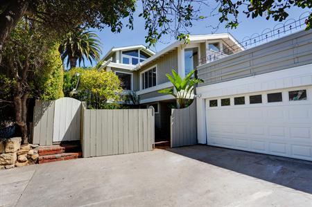 764 Moreno Road Santa Barbara, CA 93103 - Photo 1 of 18 a view of a white house with large windows and palm tree