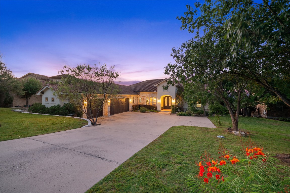 a front view of a house with a big yard and a large tree