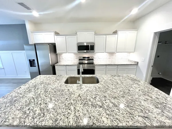 a bathroom with a granite countertop shower and a sink