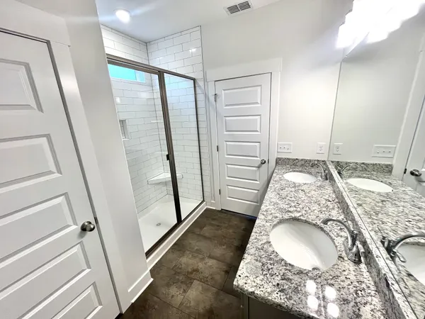 a bathroom with a granite countertop sink toilet and shower