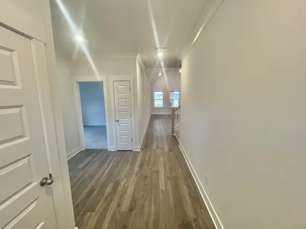 a large white kitchen with kitchen island a stove a sink dishwasher and a fireplace with wooden floor