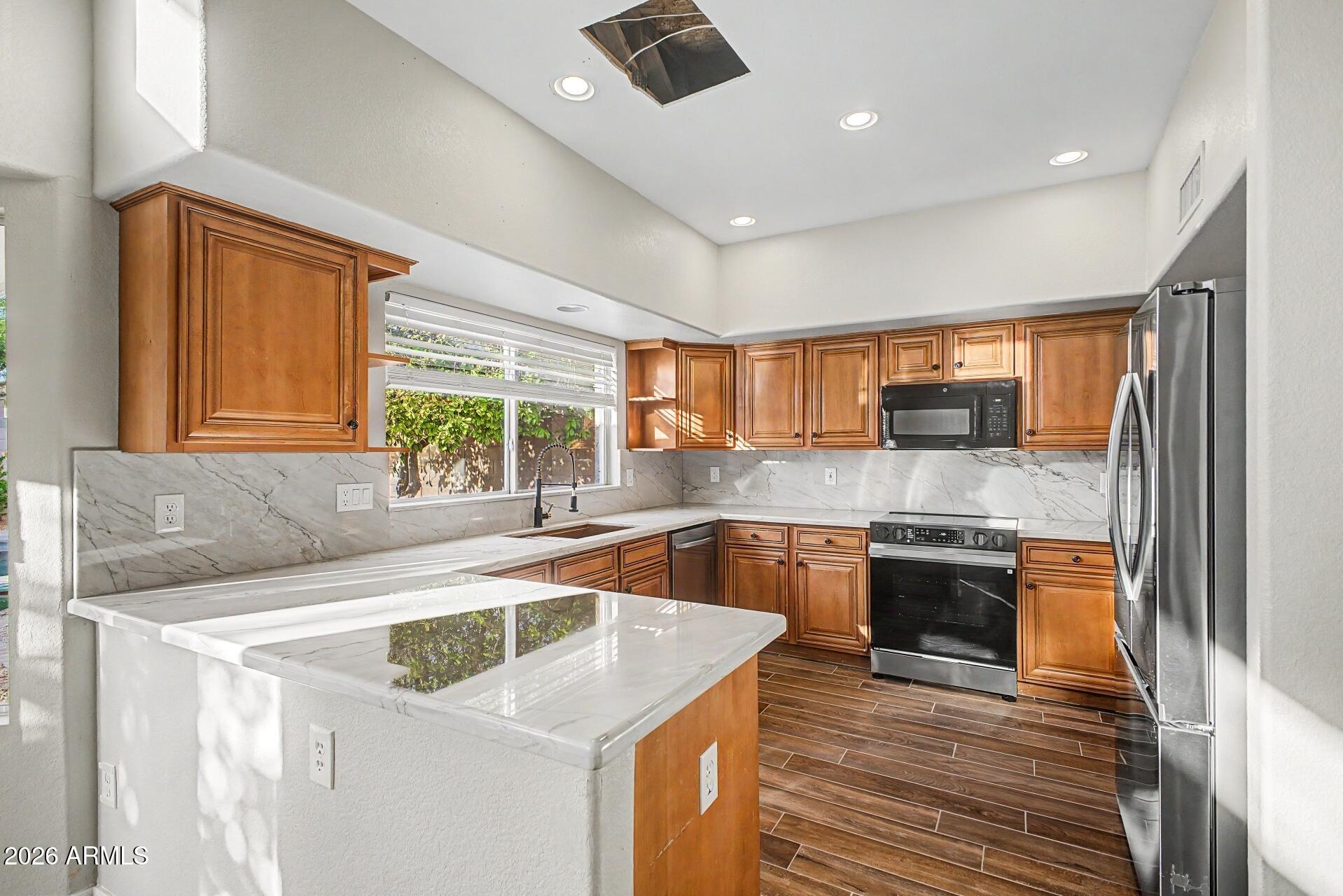4522 East Rowel Road Phoenix, AZ 85050 - Photo 10 of 61 a kitchen with stainless steel appliances granite countertop a sink stove and refrigerator