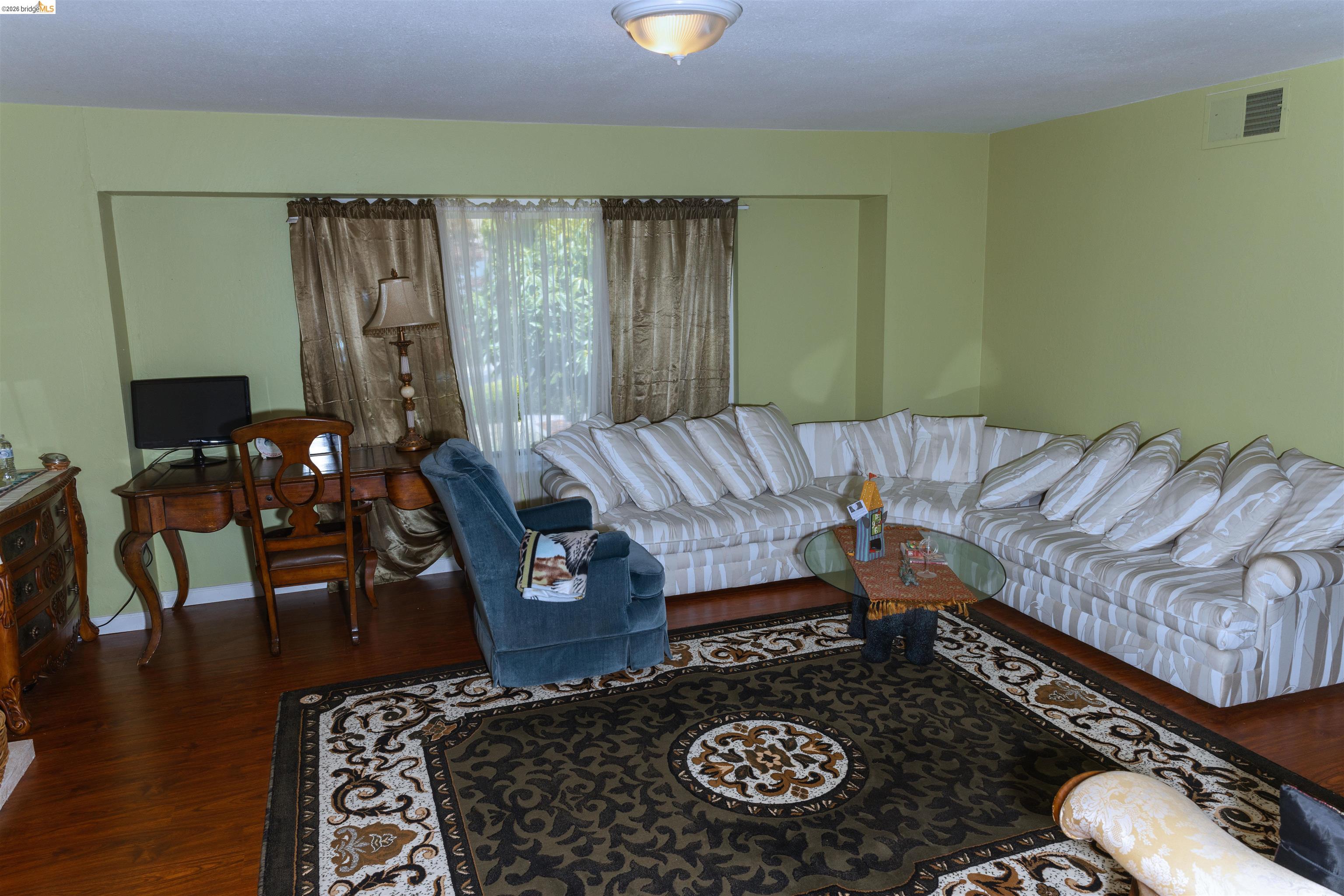 767 Marlesta Road Pinole, CA 94564 - Photo 15 of 16 Living area featuring wood-finish flooring, a large area rug, and light green wall paint