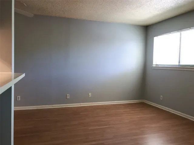 a room with wooden floor and windows