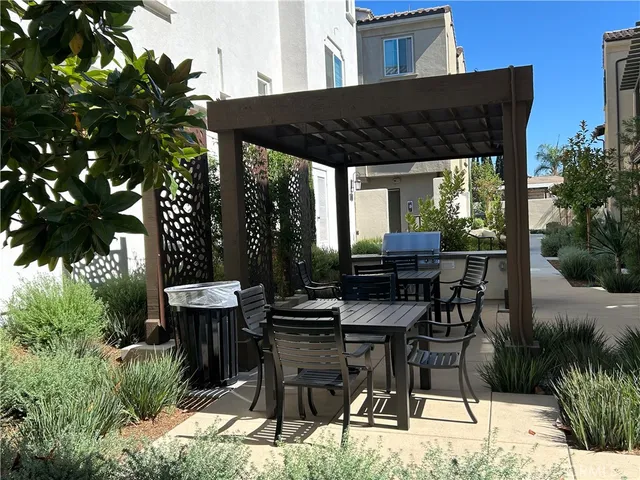 a patio with table and chairs and potted plants