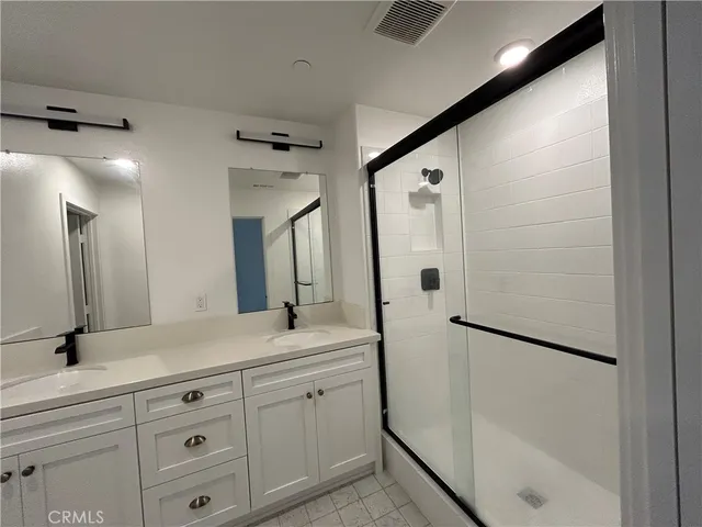a bathroom with a double vanity sink shower and a mirror