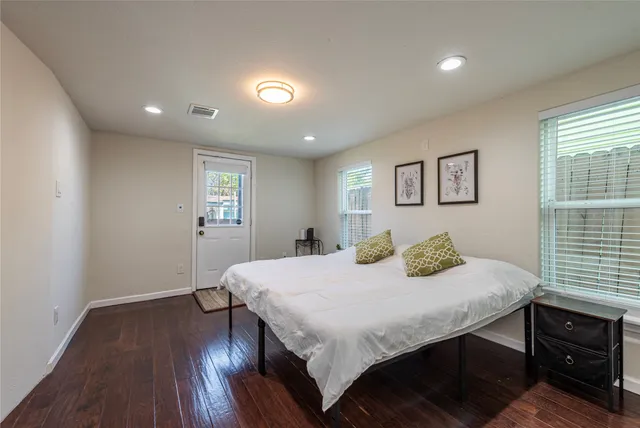 a bedroom with a bed and wooden floor
