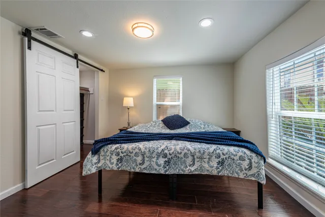 a bedroom with a bed and wooden floor