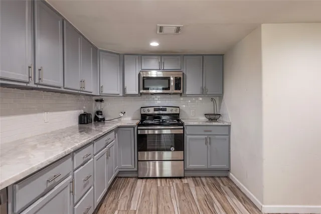 a kitchen with granite countertop a stove and a sink