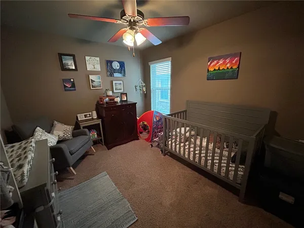 a bedroom with furniture and a chandelier fan