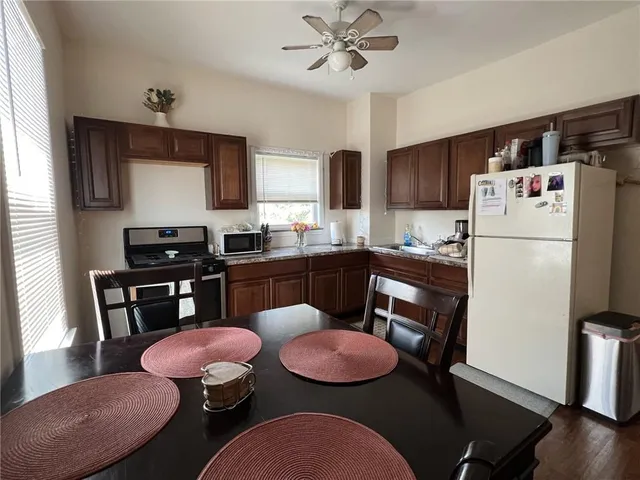 a kitchen with a refrigerator coffee maker on top of it